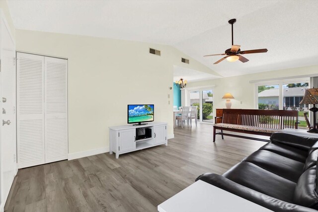 3146 37th Ln S Unit A, Saint Petersburg, FL 33711 - living area with ceiling fan, light wood-style flooring, vaulted ceiling, a chandelier, and baseboards