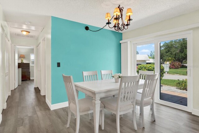 3146 37th Ln S Unit A, Saint Petersburg, FL 33711 - dining area with wood finished floors, a chandelier, baseboards, and a textured ceiling