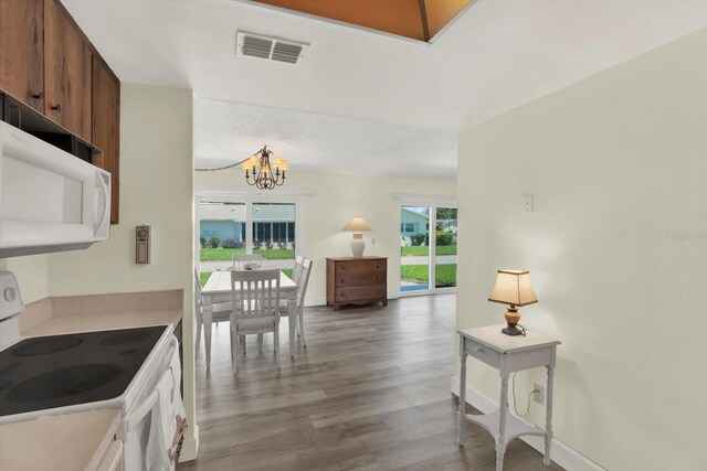 3146 37th Ln S Unit A, Saint Petersburg, FL 33711 - kitchen featuring white appliances, a chandelier, wood finished floors, baseboards, and light countertops