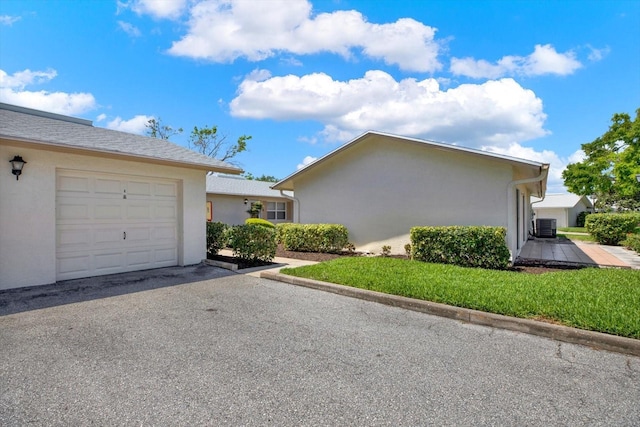 3146 37th Ln S Unit A, Saint Petersburg, FL 33711 - view of property exterior featuring stucco siding, cooling unit, a garage, and driveway