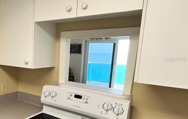 880 Mandalay Ave Unit C1103, Clearwater Beach, FL 33767 - kitchen view of stove and white cabinets