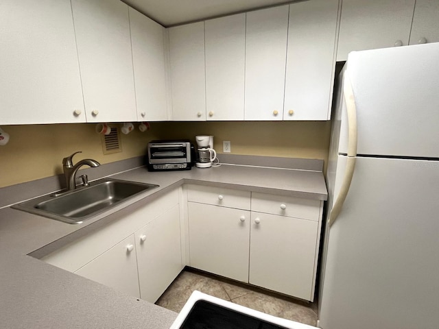 880 Mandalay Ave Unit C1103, Clearwater Beach, FL 33767 - kitchen with freestanding refrigerator, a sink, and white cabinetry