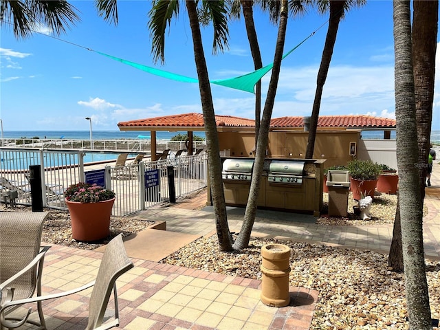 880 Mandalay Ave Unit C1103, Clearwater Beach, FL 33767 - view of patio featuring a water view, a community pool, and a gate