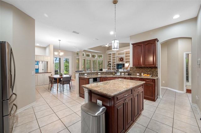 3000 Naughton Way, Tarpon Springs, FL 34688 - kitchen with freestanding refrigerator, light tile patterned floors, a peninsula, decorative backsplash, and recessed lighting