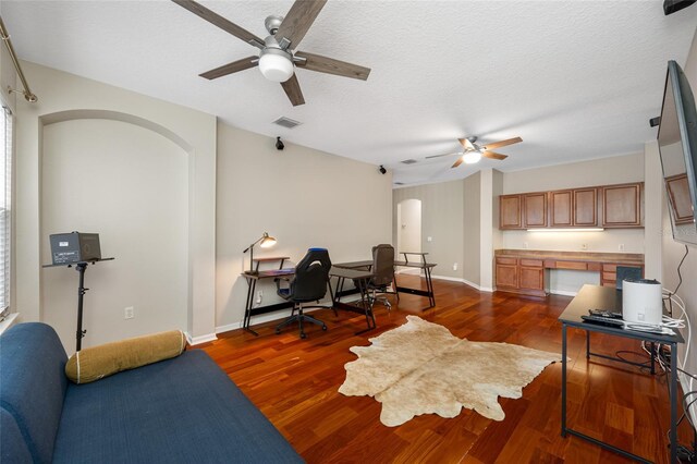 3000 Naughton Way, Tarpon Springs, FL 34688 - home office with ceiling fan, arched walkways, dark wood-type flooring, baseboards, and a textured ceiling