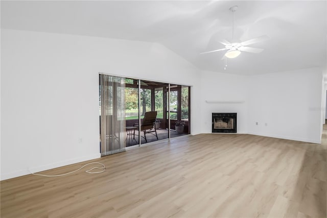 13898 Egret Ln, Clearwater, FL 33762 - unfurnished living room featuring lofted ceiling, light wood-type flooring, a fireplace, ceiling fan, and baseboards