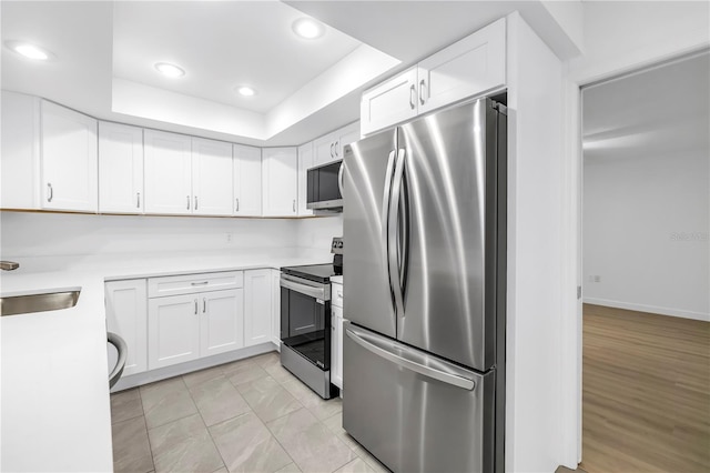 13898 Egret Ln, Clearwater, FL 33762 - kitchen with appliances with stainless steel finishes, white cabinets, light countertops, recessed lighting, and a sink