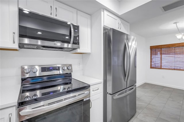 13898 Egret Ln, Clearwater, FL 33762 - kitchen with appliances with stainless steel finishes, light countertops, white cabinetry, and hanging light fixtures