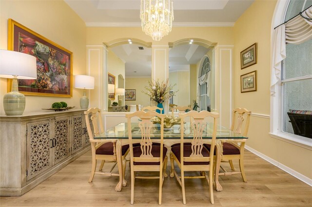 8444 Shenandoah Run, Wesley Chapel, FL 33544 - dining area with a chandelier, light wood-style flooring, arched walkways, and ornamental molding