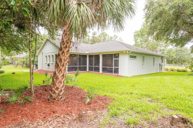 8444 Shenandoah Run, Wesley Chapel, FL 33544 - back of house featuring a sunroom, stucco siding, and a lawn