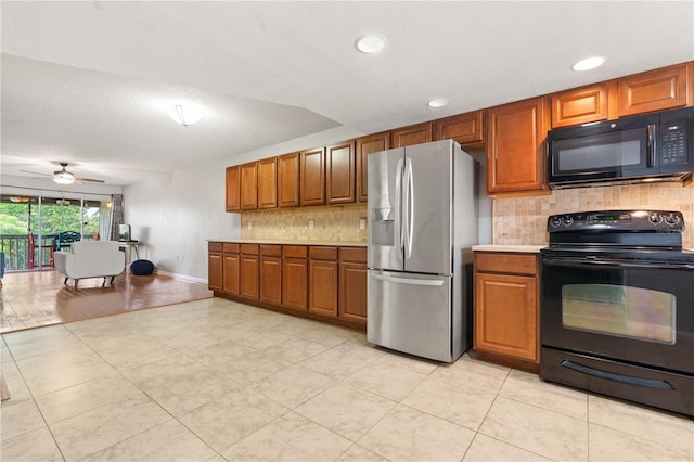 1028 Apollo Beach Blvd Unit 203, Apollo Beach, FL 33572 - kitchen with black appliances, brown cabinetry, decorative backsplash, ceiling fan, and light countertops