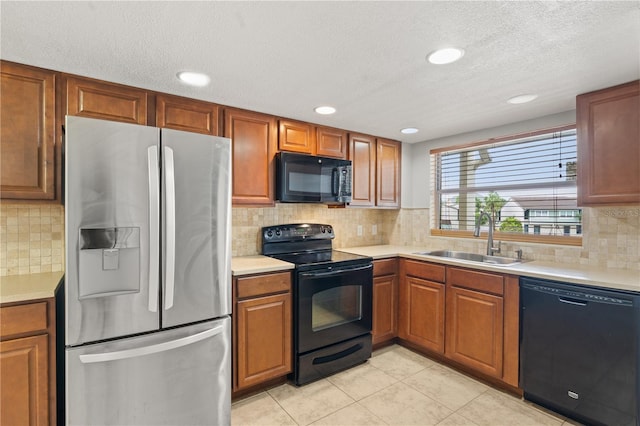 1028 Apollo Beach Blvd Unit 203, Apollo Beach, FL 33572 - kitchen featuring black appliances, light countertops, brown cabinetry, light tile patterned floors, and a textured ceiling