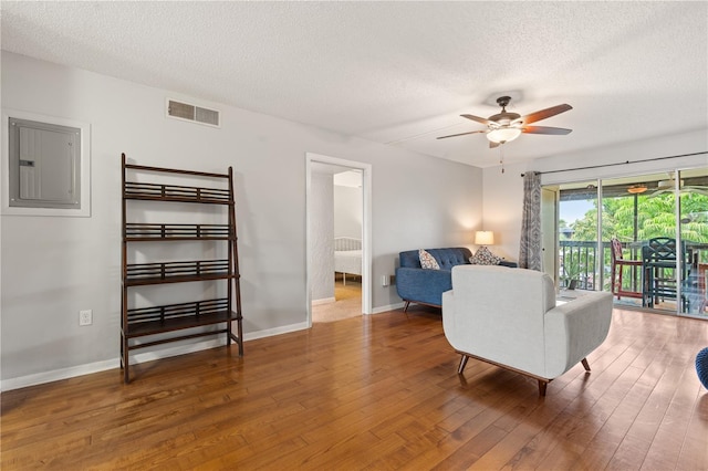 1028 Apollo Beach Blvd Unit 203, Apollo Beach, FL 33572 - living room with electric panel, a textured ceiling, a ceiling fan, and wood finished floors