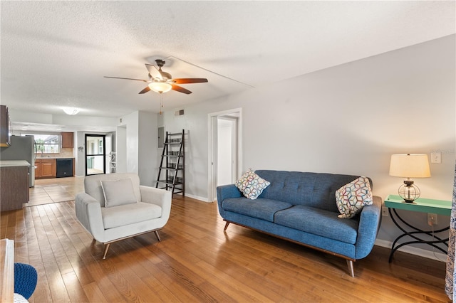 1028 Apollo Beach Blvd Unit 203, Apollo Beach, FL 33572 - living room featuring light wood finished floors, a ceiling fan, and a textured ceiling