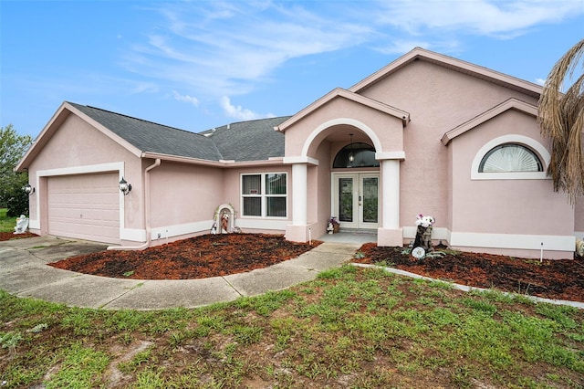 12214 Buckingham Way, Spring Hill, FL 34609 - view of front of house featuring french doors, an attached garage, stucco siding, and concrete driveway