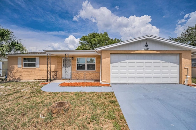 9100 Lunar Ln, Port Richey, FL 34668 - ranch-style home with driveway, an attached garage, a front lawn, and a porch