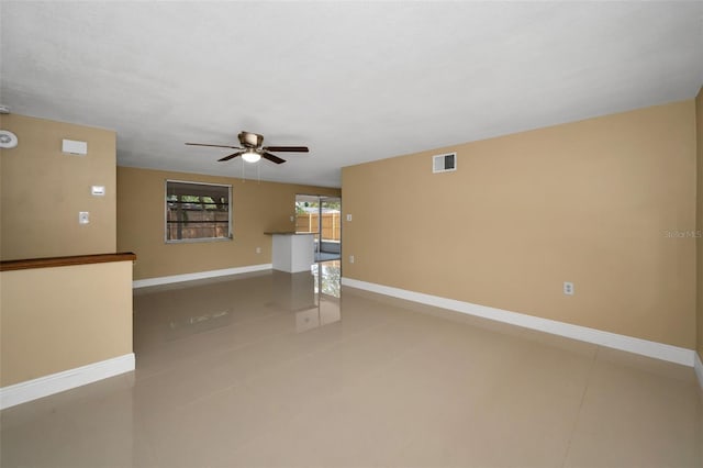 9100 Lunar Ln, Port Richey, FL 34668 - unfurnished living room with tile patterned flooring, ceiling fan, and baseboards