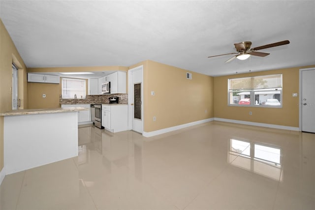9100 Lunar Ln, Port Richey, FL 34668 - unfurnished living room featuring ceiling fan, baseboards, light tile patterned floors, and a sink