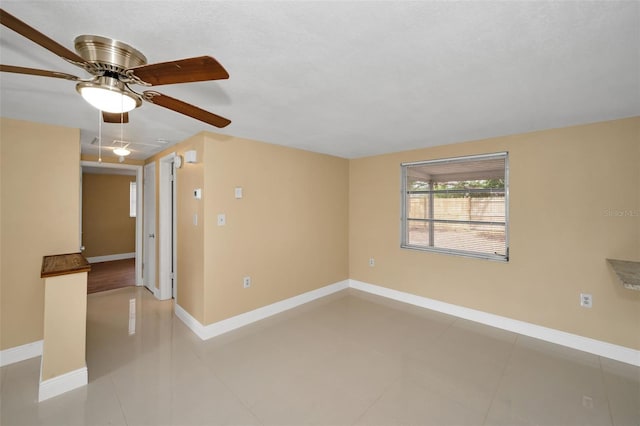 9100 Lunar Ln, Port Richey, FL 34668 - empty room featuring ceiling fan, baseboards, and light tile patterned floors
