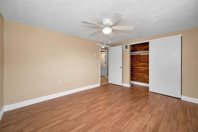 9100 Lunar Ln, Port Richey, FL 34668 - unfurnished bedroom featuring light wood-type flooring, baseboards, a closet, and a ceiling fan