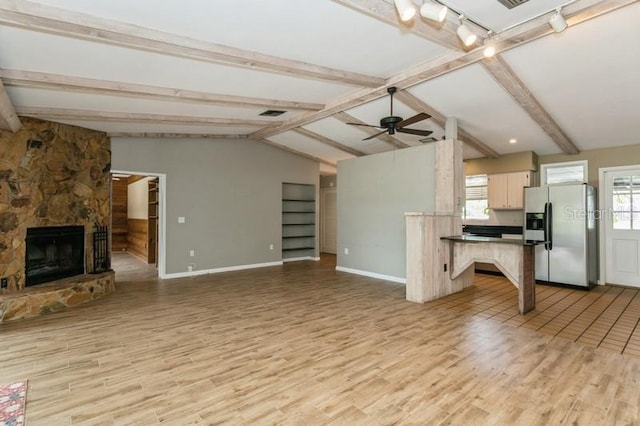 2035 Nolan Dr, Dunedin, FL 34698 - unfurnished living room featuring light wood-type flooring, a ceiling fan, and a stone fireplace
