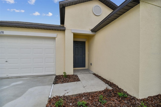 9828 Branching Ship Trce, Wesley Chapel, FL 33545 - doorway to property with stucco siding, an attached garage, and concrete driveway