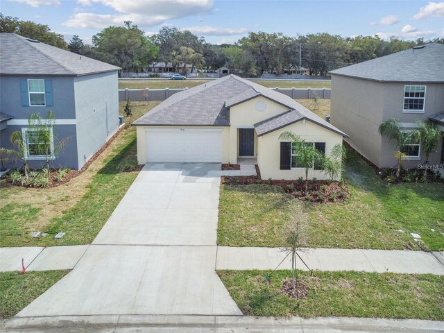 9828 Branching Ship Trce, Wesley Chapel, FL 33545 - view of front of property with an attached garage, concrete driveway, a front yard, and roof with shingles