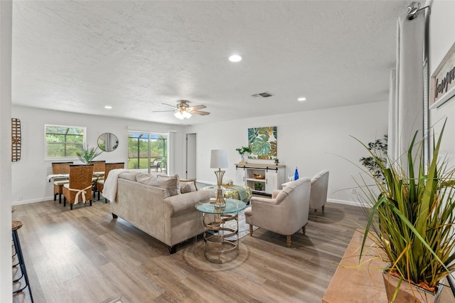 3956 N Tamarisk Pt, Beverly Hills, FL 34465 - living room featuring wood finished floors, ceiling fan, a textured ceiling, baseboards, and recessed lighting