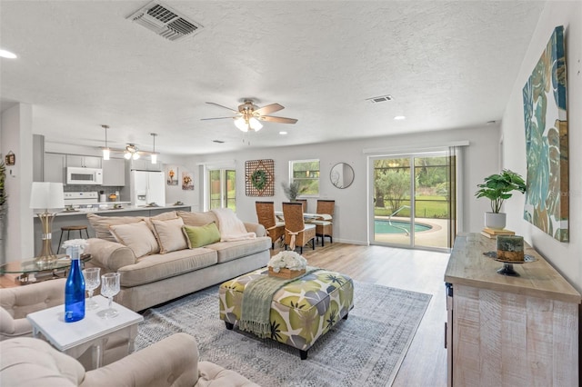 3956 N Tamarisk Pt, Beverly Hills, FL 34465 - living area featuring light wood-style flooring, recessed lighting, a ceiling fan, a textured ceiling, and baseboards
