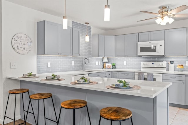 3956 N Tamarisk Pt, Beverly Hills, FL 34465 - kitchen featuring white appliances, a peninsula, gray cabinetry, and tasteful backsplash
