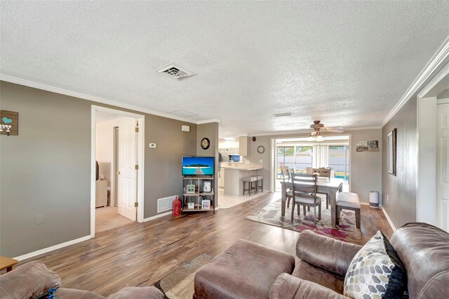 260 Venice E Blvd, Venice, FL 34293 - living area featuring wood finished floors, a ceiling fan, ornamental molding, baseboards, and a textured ceiling