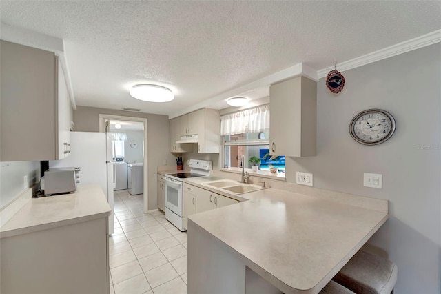 260 Venice E Blvd, Venice, FL 34293 - kitchen with electric stove, a sink, washer and dryer, a peninsula, and light countertops