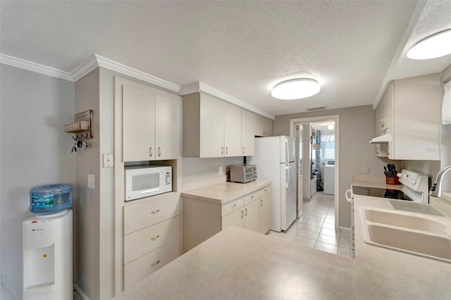 260 Venice E Blvd, Venice, FL 34293 - kitchen featuring white appliances, a textured ceiling, light tile patterned flooring, washer / dryer, and light countertops