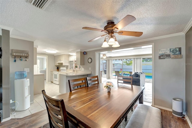 260 Venice E Blvd, Venice, FL 34293 - dining room with a textured ceiling, ornamental molding, a ceiling fan, light wood finished floors, and baseboards