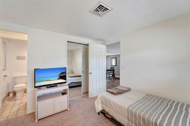 260 Venice E Blvd, Venice, FL 34293 - bedroom featuring a closet, baseboards, a barn door, light colored carpet, and a textured ceiling