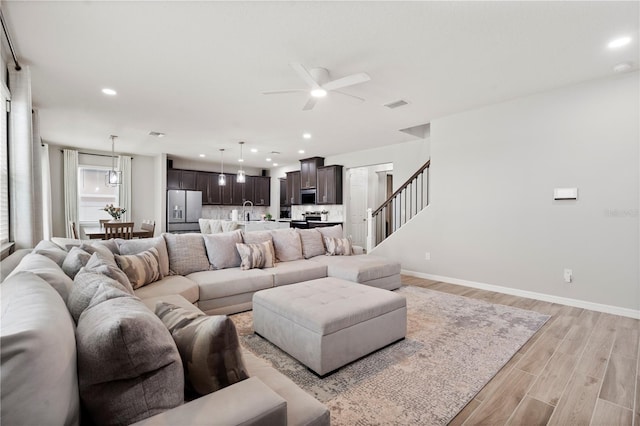 11719 Tetrafin Dr, Riverview, FL 33579 - living room with ceiling fan, light wood-style flooring, baseboards, recessed lighting, and stairway