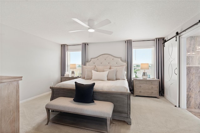 11719 Tetrafin Dr, Riverview, FL 33579 - bedroom with light carpet, a textured ceiling, a barn door, ceiling fan, and baseboards