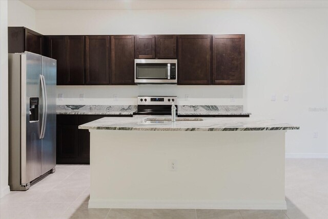 11054 Crescent Deer Dr, Land O Lakes, FL 34638 - kitchen with appliances with stainless steel finishes, a sink, light stone countertops, an island with sink, and dark brown cabinetry