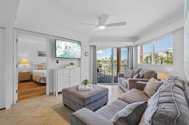5445 Gulf Blvd Unit 210, St Pete Beach, FL 33706 - living room featuring light tile patterned floors, a ceiling fan, a textured ceiling, and a water view