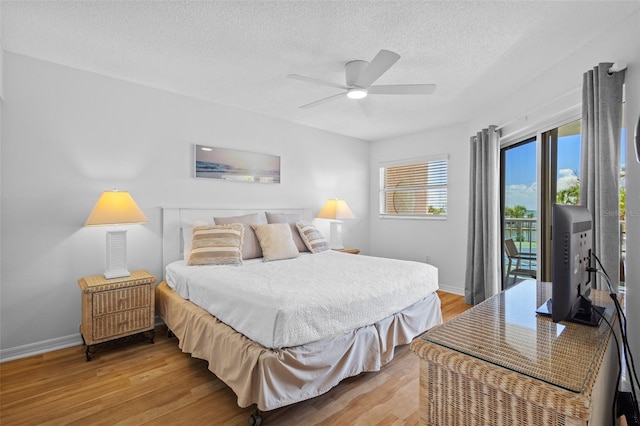 5445 Gulf Blvd Unit 210, St Pete Beach, FL 33706 - bedroom featuring access to outside, light wood finished floors, baseboards, a textured ceiling, and ceiling fan