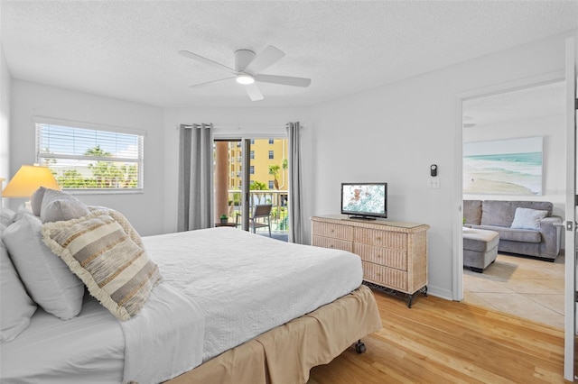 5445 Gulf Blvd Unit 210, St Pete Beach, FL 33706 - bedroom with light wood finished floors, a textured ceiling, ceiling fan, access to outside, and baseboards