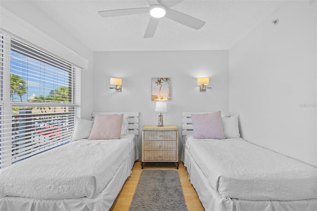 5445 Gulf Blvd Unit 210, St Pete Beach, FL 33706 - bedroom featuring light wood finished floors, ceiling fan, and a textured ceiling