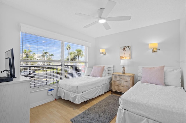 5445 Gulf Blvd Unit 210, St Pete Beach, FL 33706 - bedroom featuring light wood finished floors, a ceiling fan, and baseboards