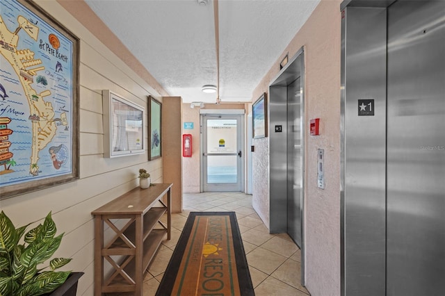 5445 Gulf Blvd Unit 210, St Pete Beach, FL 33706 - hall with elevator, a textured ceiling, and light tile patterned floors