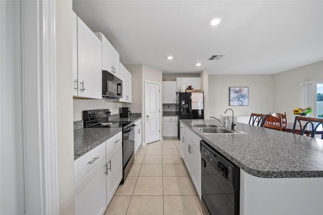 4403 Eternal Prince, Sun City Center, FL 33573 - kitchen with black appliances, a sink, white cabinetry, dark countertops, and a kitchen island with sink