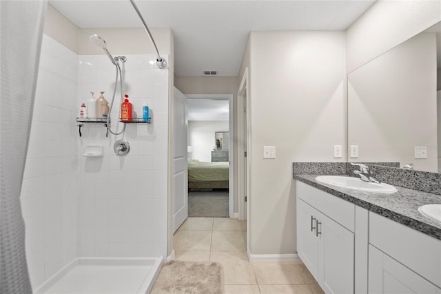 4403 Eternal Prince, Sun City Center, FL 33573 - ensuite bathroom featuring tiled shower, double vanity, tile patterned flooring, and baseboards