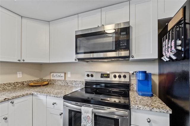 12529 Mondragon Dr, Tampa, FL 33625 - kitchen with stainless steel appliances, white cabinetry, and light stone counters