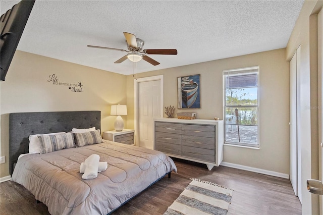 12529 Mondragon Dr, Tampa, FL 33625 - bedroom featuring baseboards, dark wood-type flooring, a textured ceiling, and ceiling fan