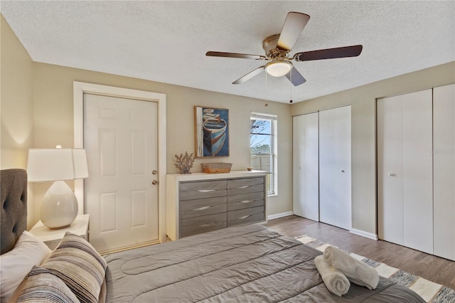 12529 Mondragon Dr, Tampa, FL 33625 - bedroom with a textured ceiling, multiple closets, wood finished floors, baseboards, and ceiling fan