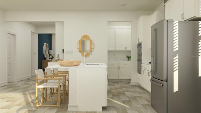 7546 E 117th Ln, Palmetto, FL 34221 - kitchen with freestanding refrigerator, a sink, light wood-style floors, and white cabinetry